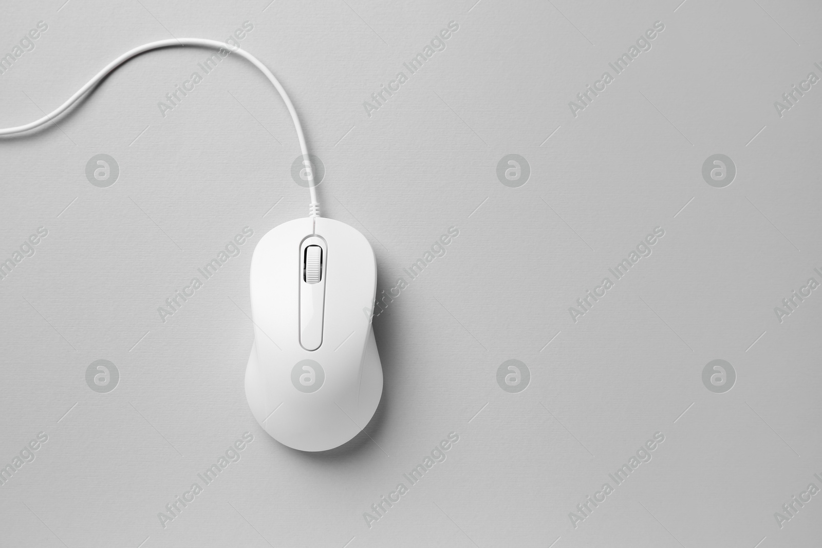 Photo of One wired mouse on grey background, top view. Space for text