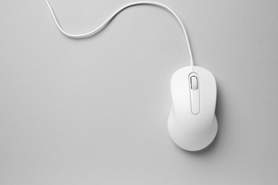 One wired mouse on grey background, top view. Space for text