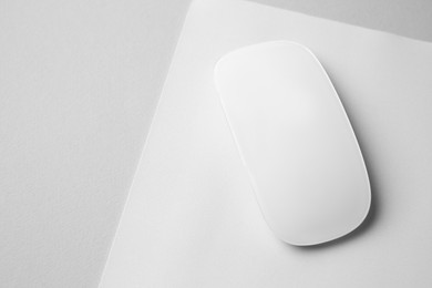 Photo of One wireless mouse with mousepad on grey background, above view. Space for text
