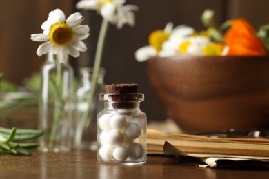 Photo of Homeopathy. Pills in glass bottle on wooden table, closeup