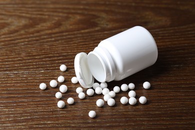 Homeopathy. Plastic bottle with pills on wooden table