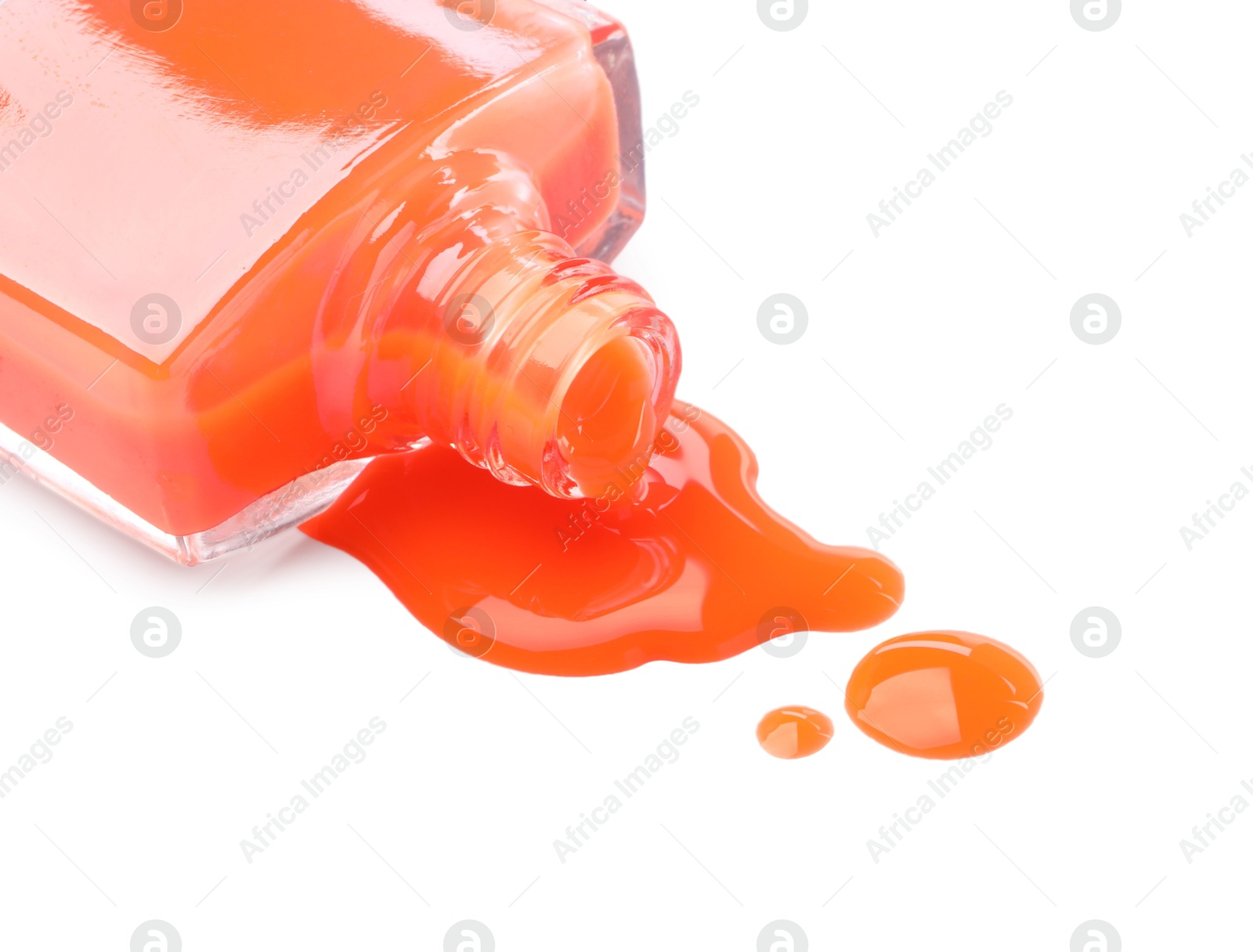Photo of Bottle and spilled orange nail polish isolated on white