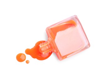 Bottle and spilled orange nail polish isolated on white, top view