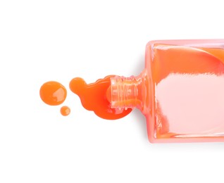 Photo of Bottle and spilled orange nail polish isolated on white, top view