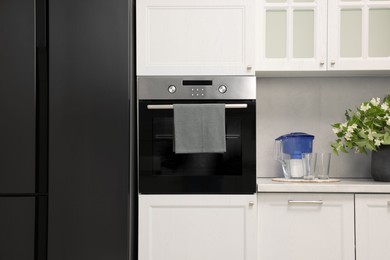 Photo of Electric oven with towel in kitchen. Cooking appliance