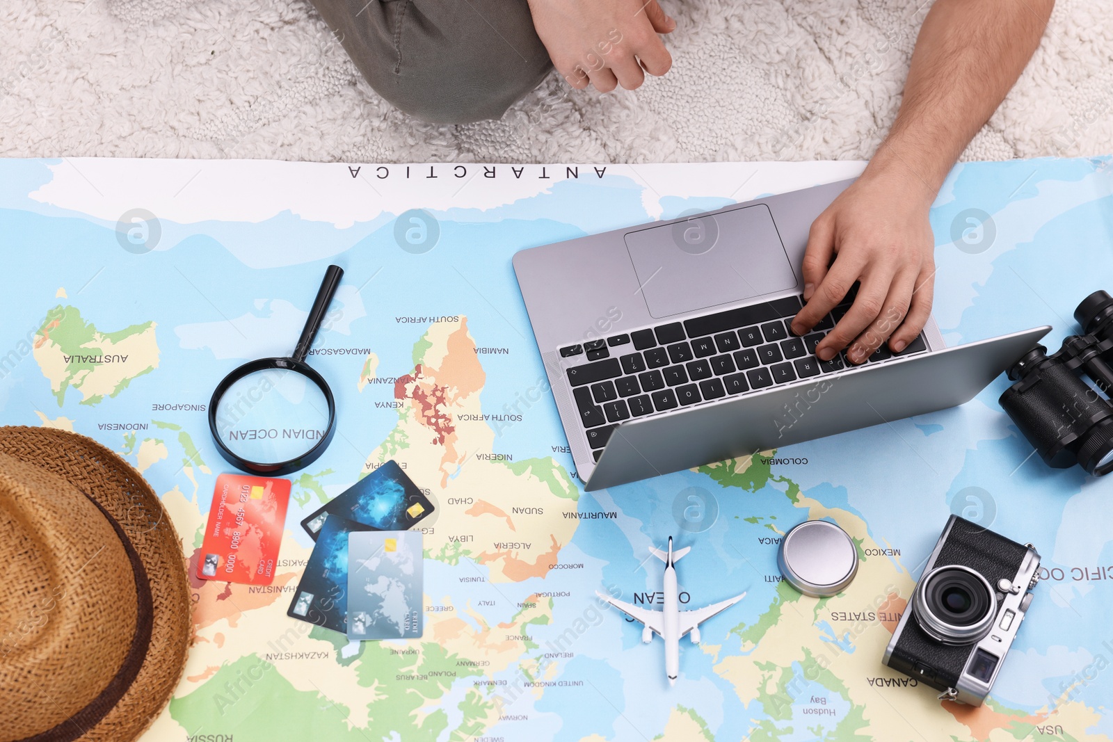Photo of Travel blogger using laptop and map for planning trip, top view