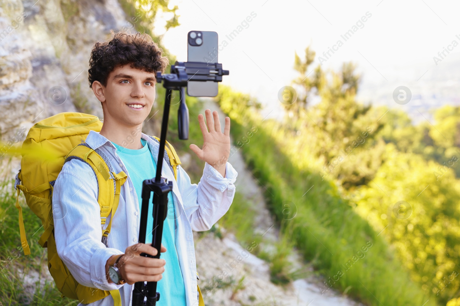 Photo of Travel blogger with smartphone and tripod streaming outdoors, space for text