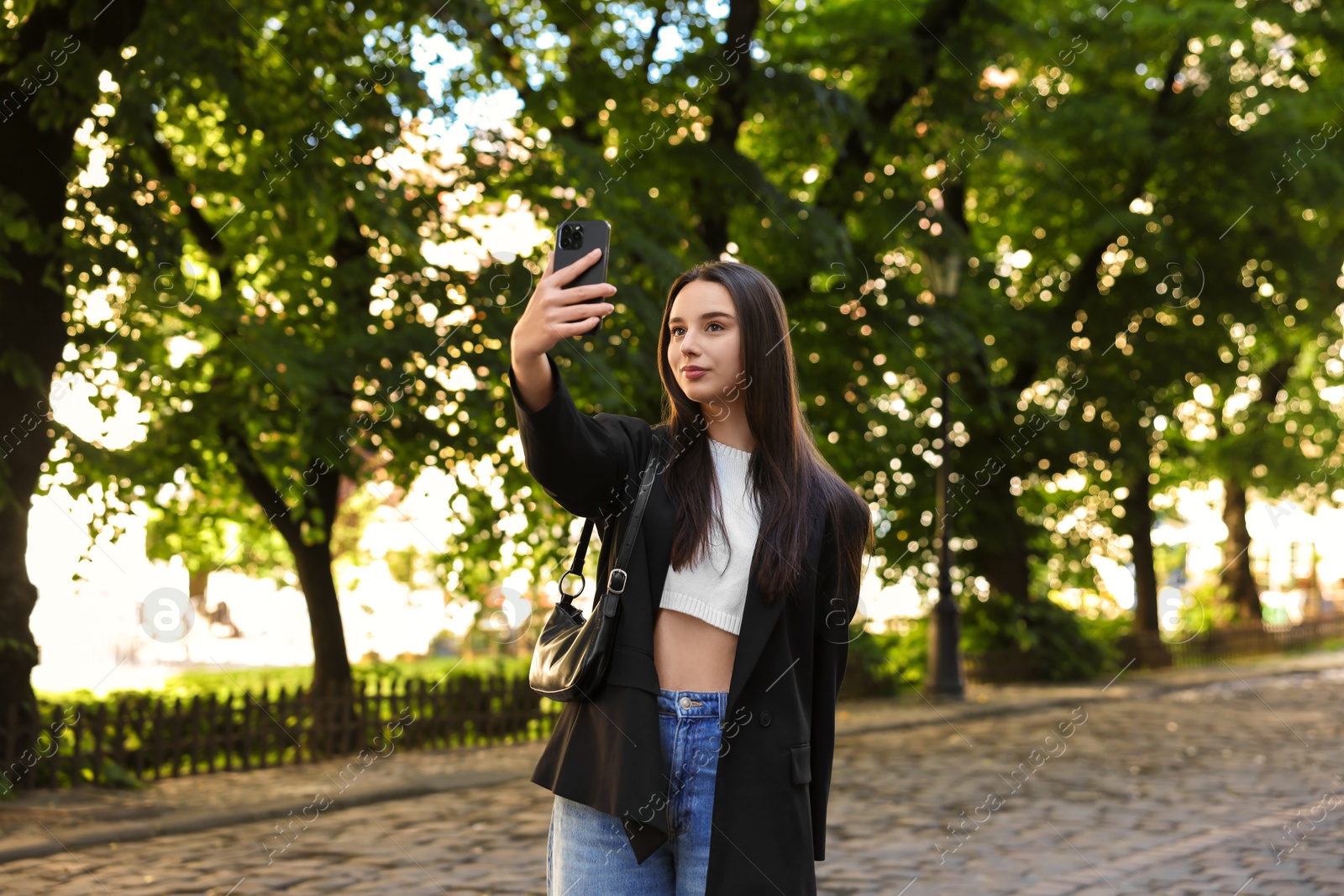 Photo of Travel blogger takIng selfie with smartphone outdoors