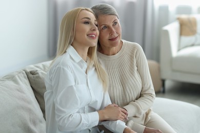 Family portrait of young woman and her mother at home