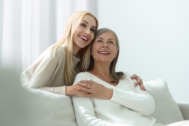 Family portrait of young woman and her mother at home