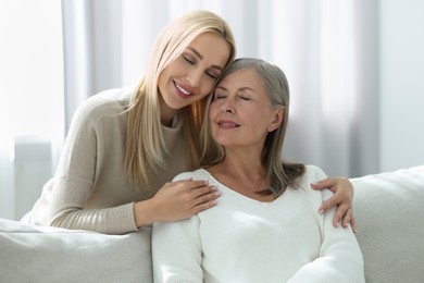 Family portrait of young woman and her mother at home