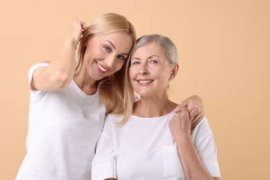 Photo of Family portrait of young woman and her mother on beige background