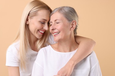 Photo of Family portrait of young woman and her mother on beige background