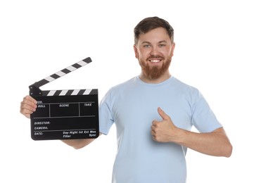 Making movie. Smiling man with clapperboard showing thumb up on white background