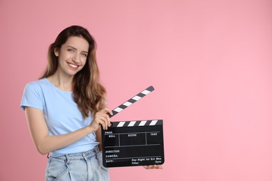 Making movie. Smiling woman with clapperboard on pink background. Space for text