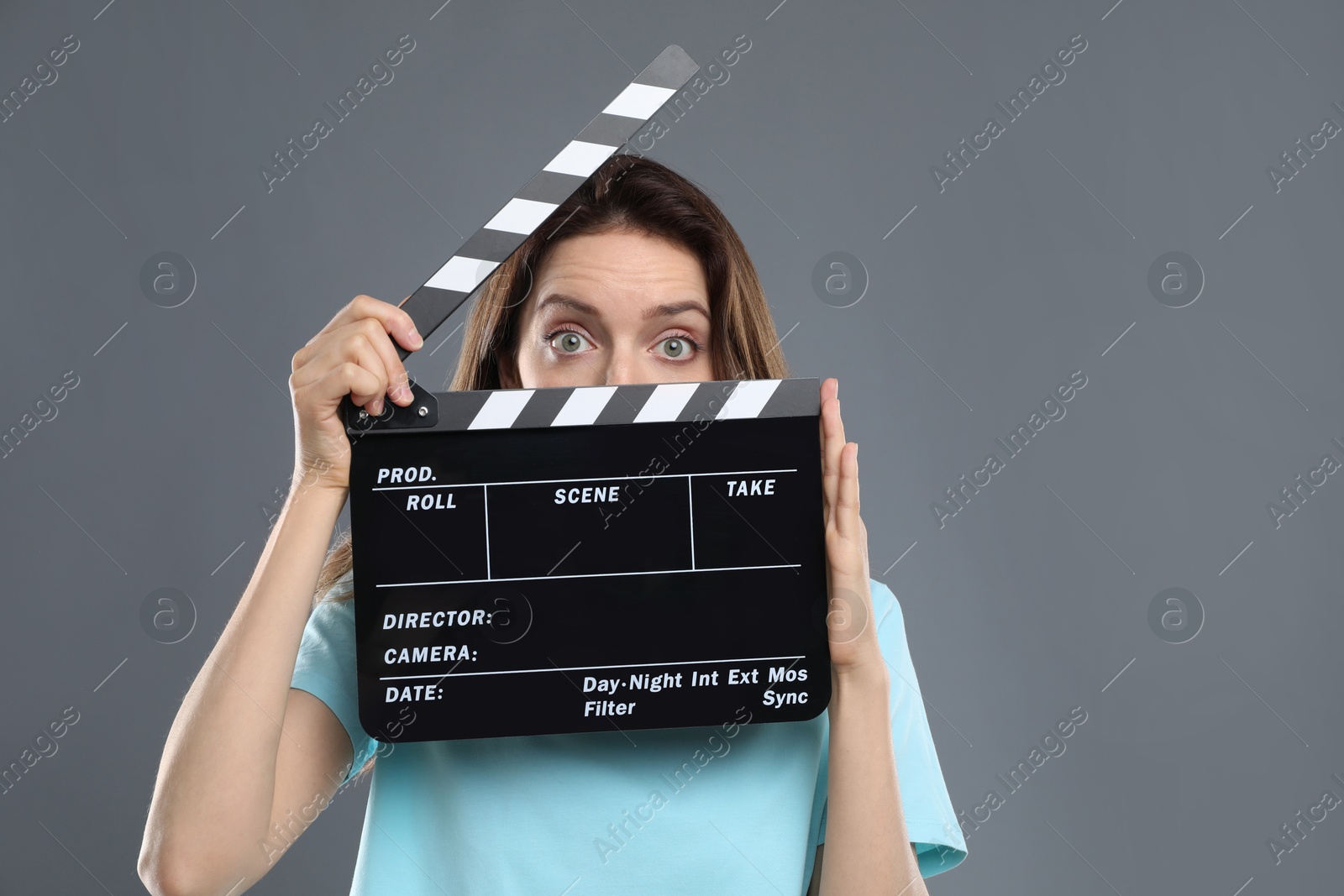 Photo of Making movie. Woman with clapperboard on grey background
