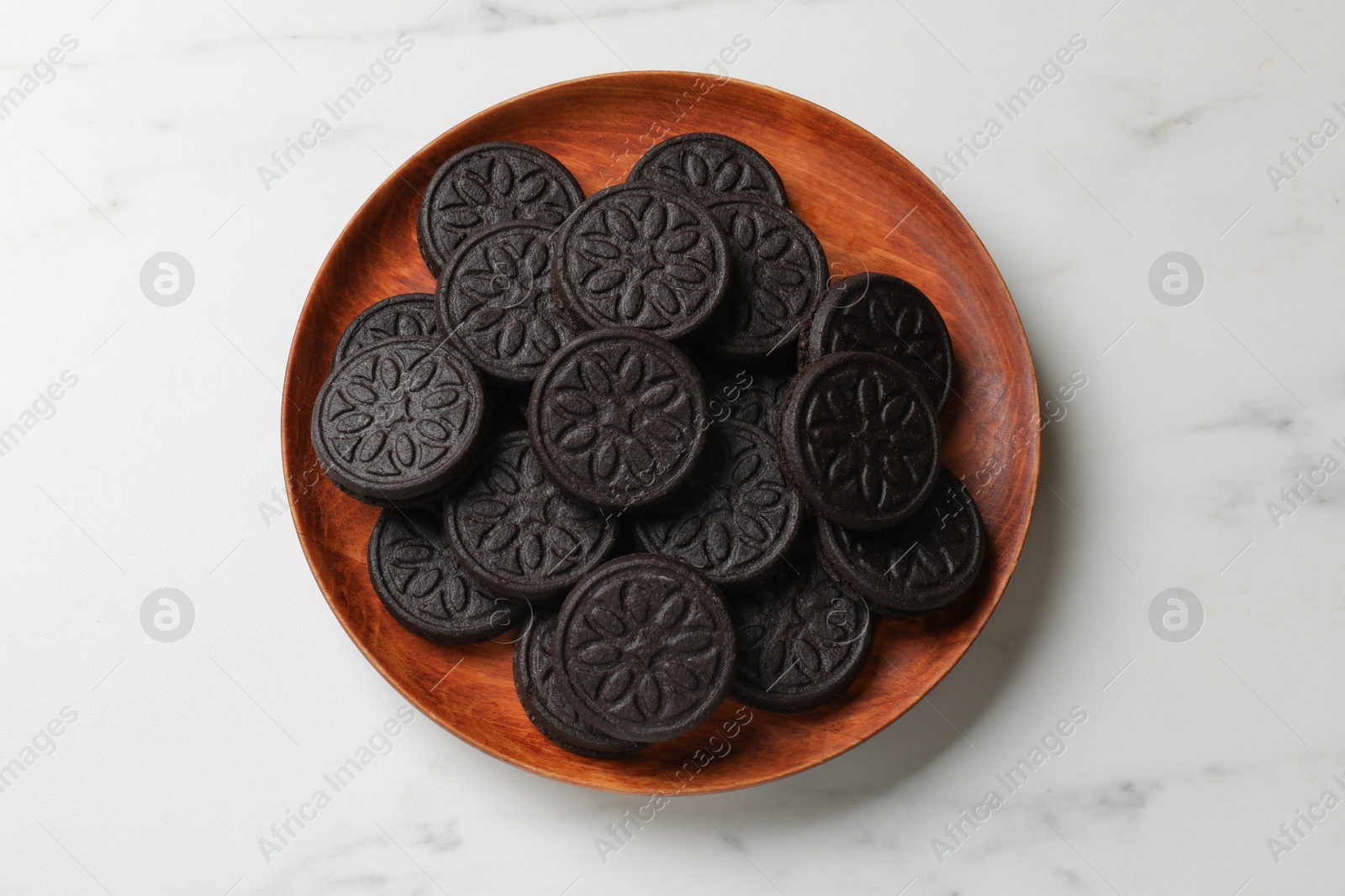 Photo of Plate with tasty sandwich cookies on white marble table, top view