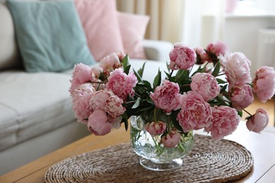 Beautiful pink peonies in vase on table at home. Interior design