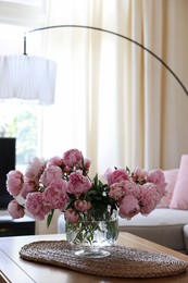 Beautiful pink peonies in vase on table at home, space for text. Interior design