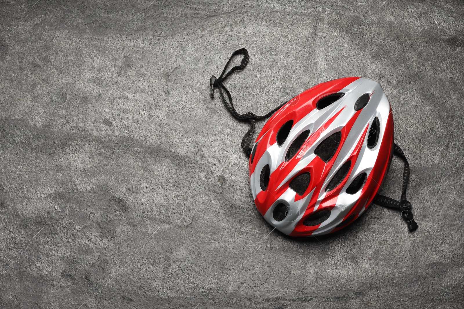 Photo of Modern protective helmet on grey stone surface, top view. Space for text