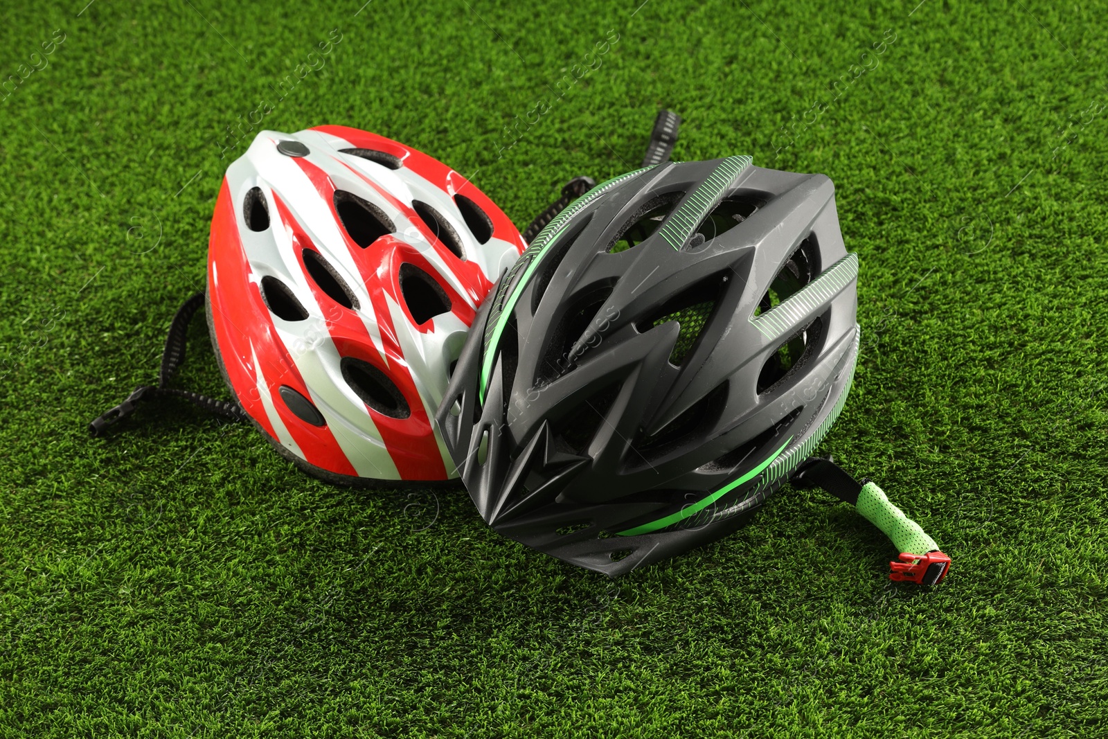 Photo of Two protective helmets on green grass. Sports equipment