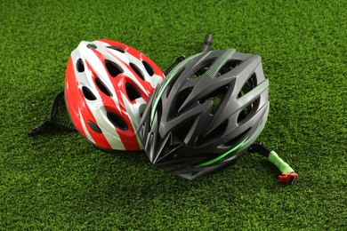 Two protective helmets on green grass. Sports equipment