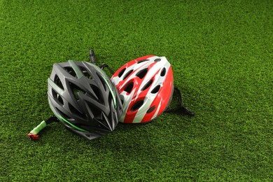 Photo of Two protective helmets on green grass. Sports equipment