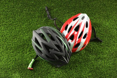 Two protective helmets on green grass. Sports equipment