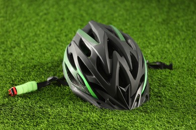 Stylish protective helmet on green grass. Sports equipment