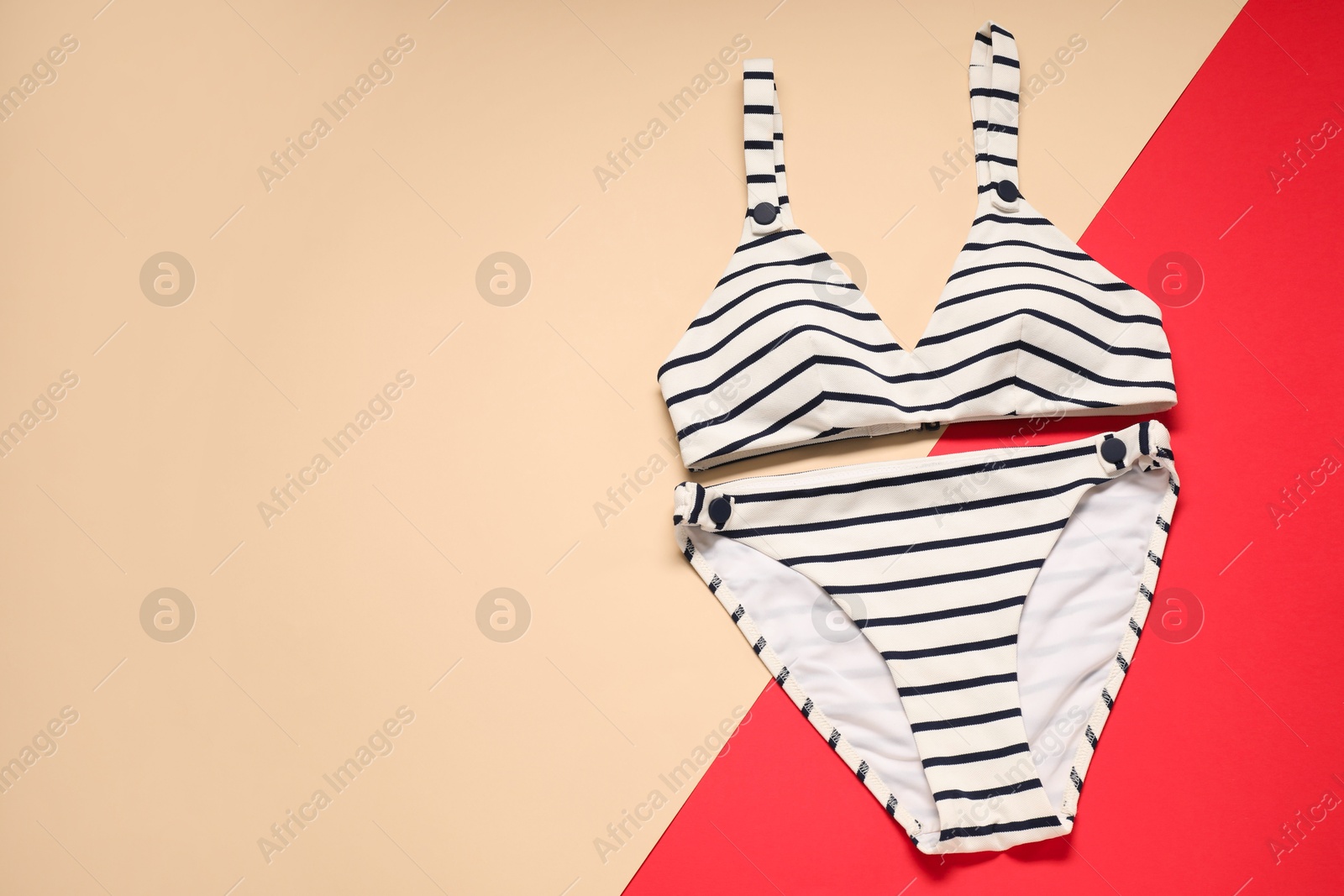 Photo of Striped swimsuit on color background, top view. Space for text