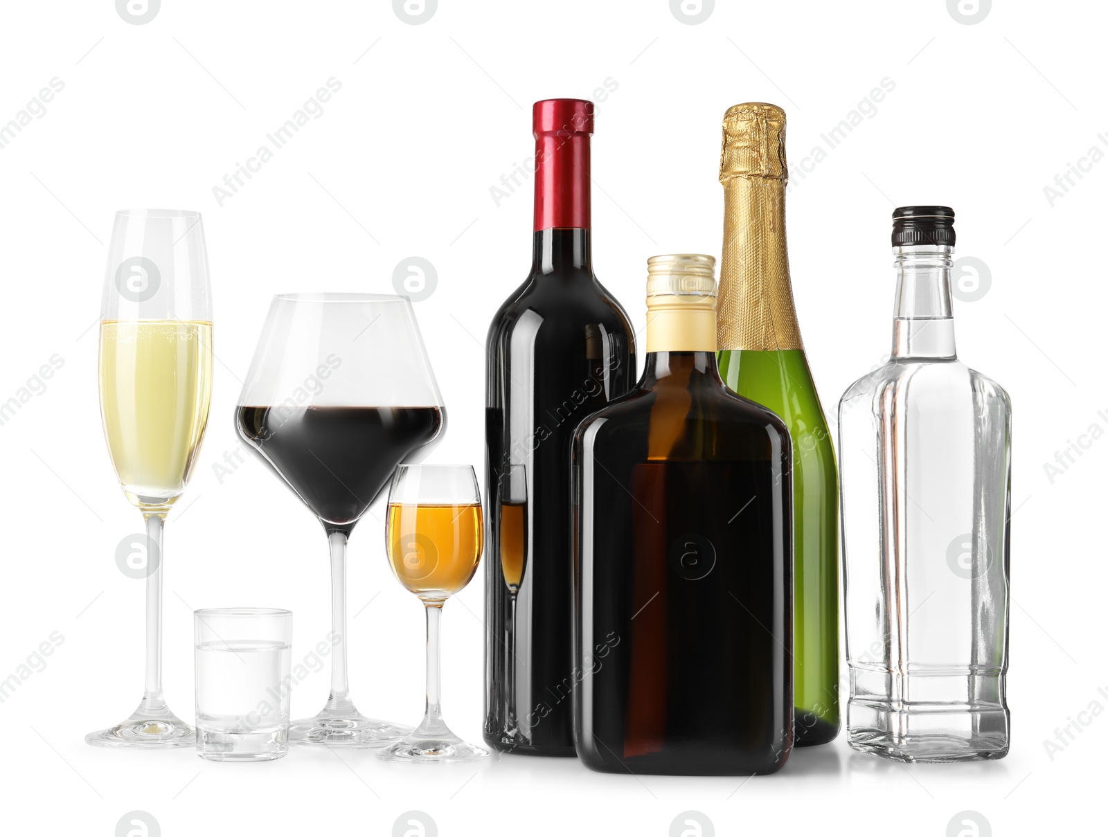 Photo of Bottles and glasses with different alcoholic drinks on white table against light background, space for text