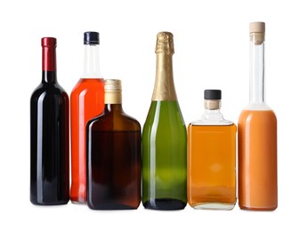 Photo of Bottles of different alcoholic drinks isolated on white