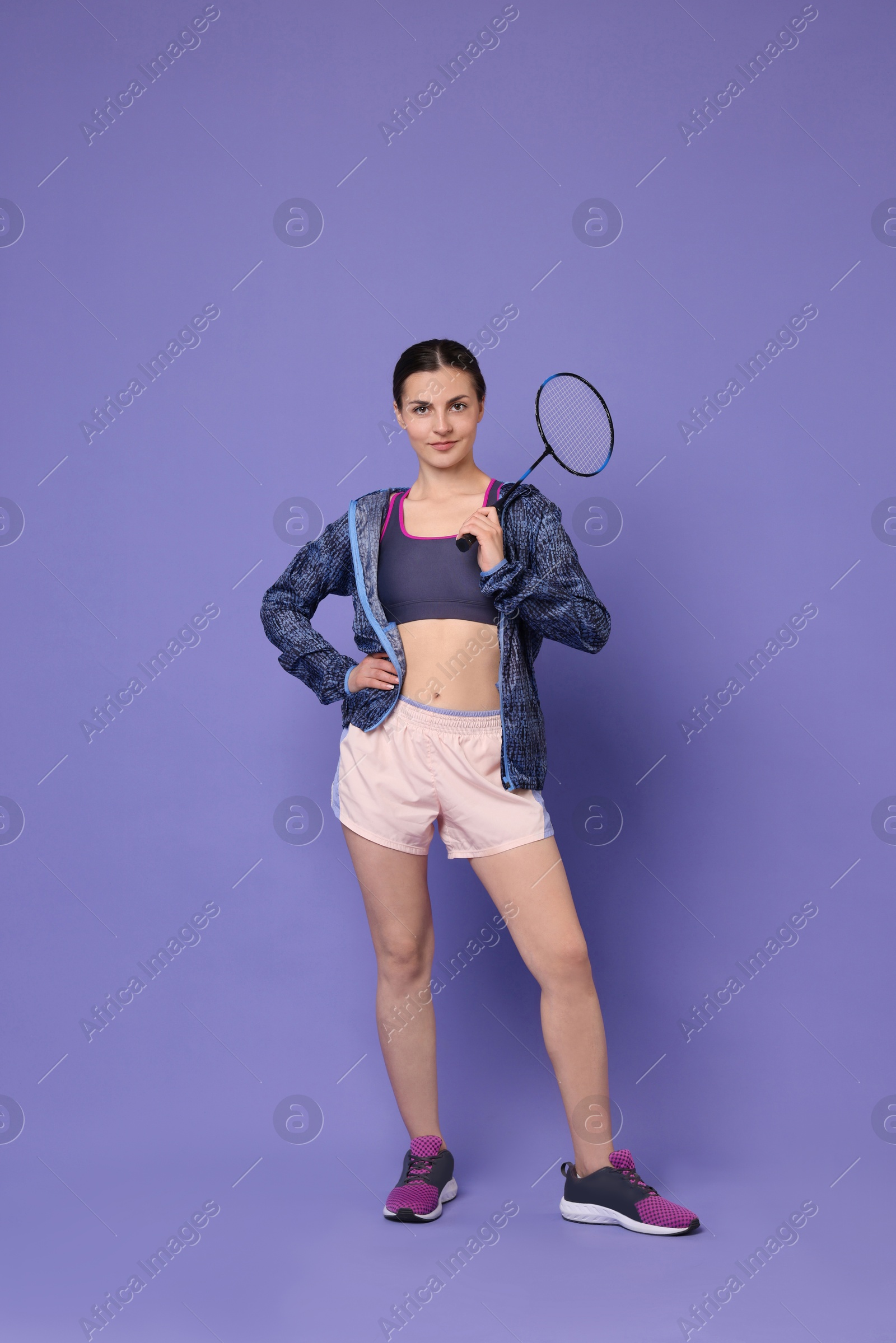 Photo of Young woman with badminton racket on purple background