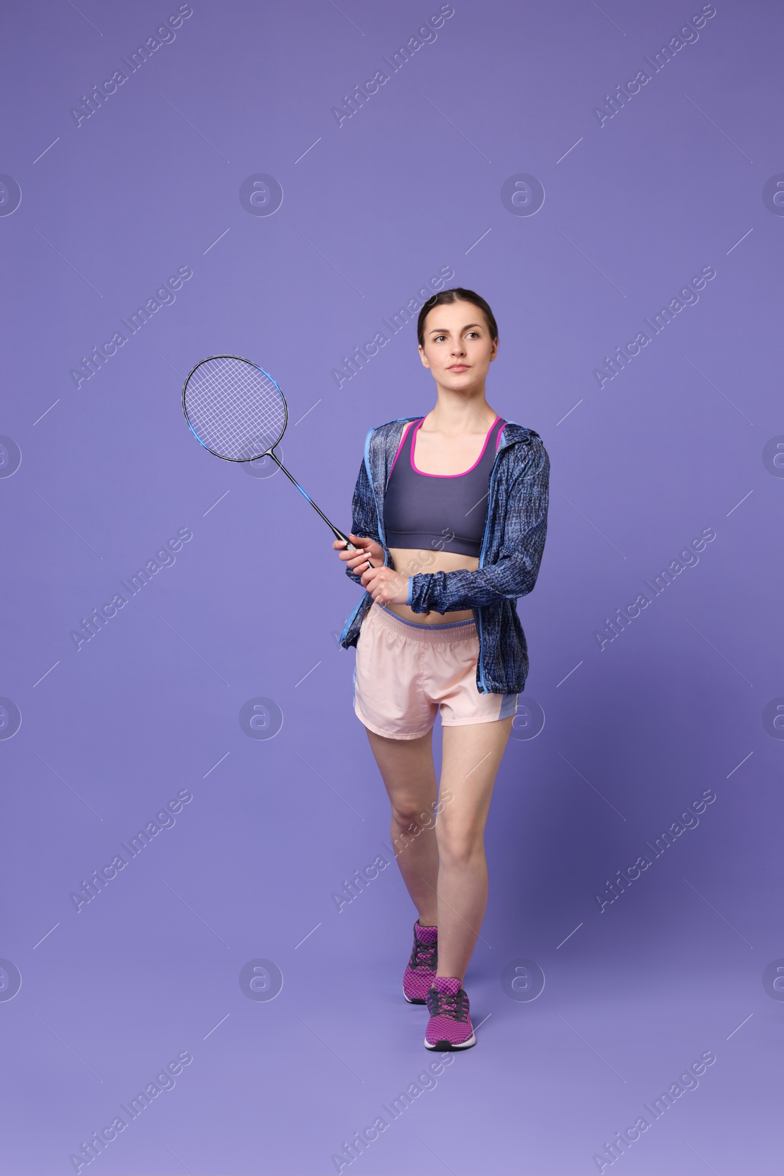 Photo of Young woman with badminton racket on purple background