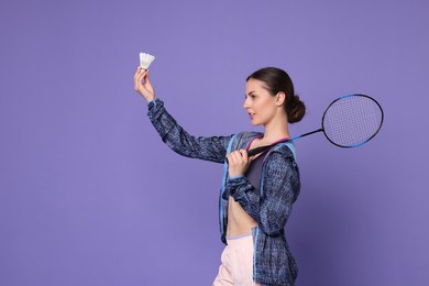 Photo of Young woman with badminton racket and shuttlecock on purple background, space for text