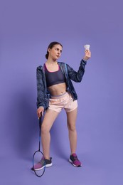 Photo of Young woman with badminton racket and shuttlecock on purple background