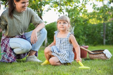 Photo of Mother and her daughter working together in garden