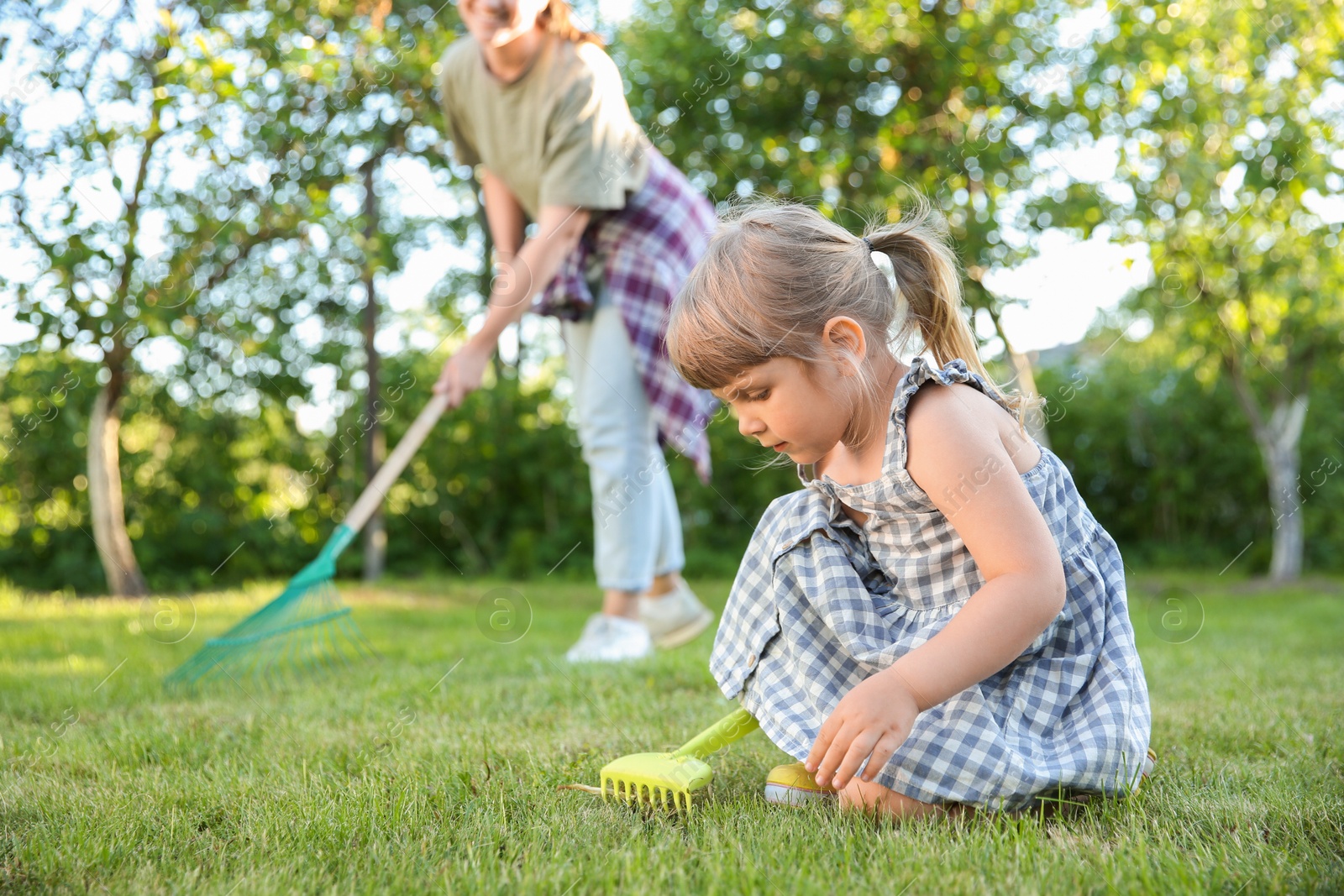 Photo of Mother and her daughter working together in garden