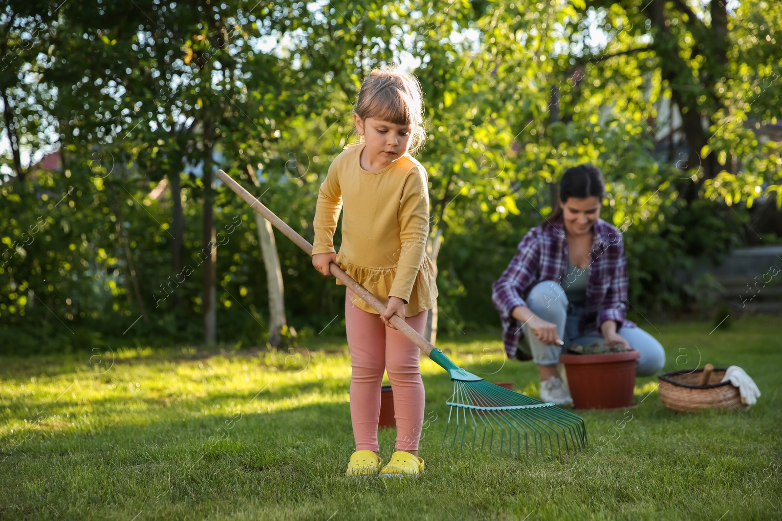 Photo of Mother and her daughter working together in garden