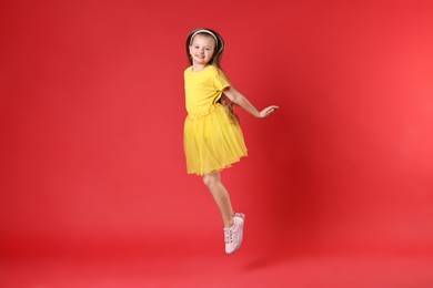 Cute little girl dancing on red background