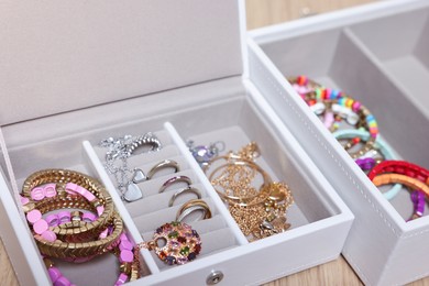 Photo of Jewelry boxes with beautiful bracelets and other accessories on table, closeup