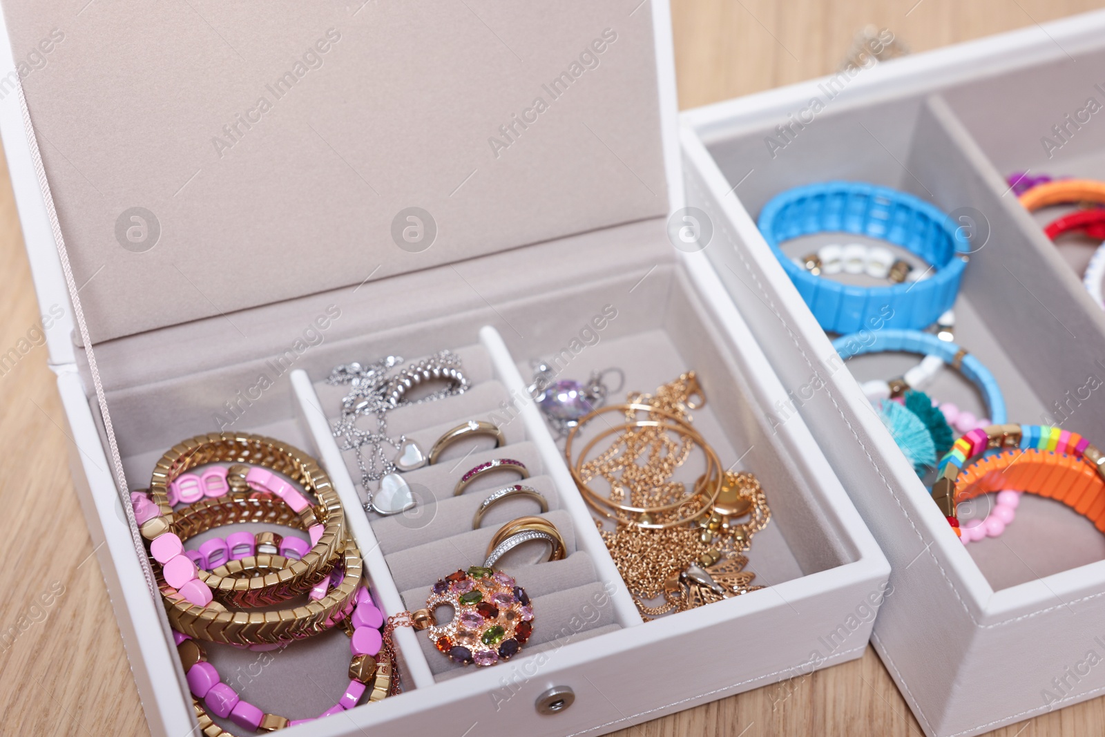 Photo of Jewelry boxes with stylish bracelets and other accessories on wooden table