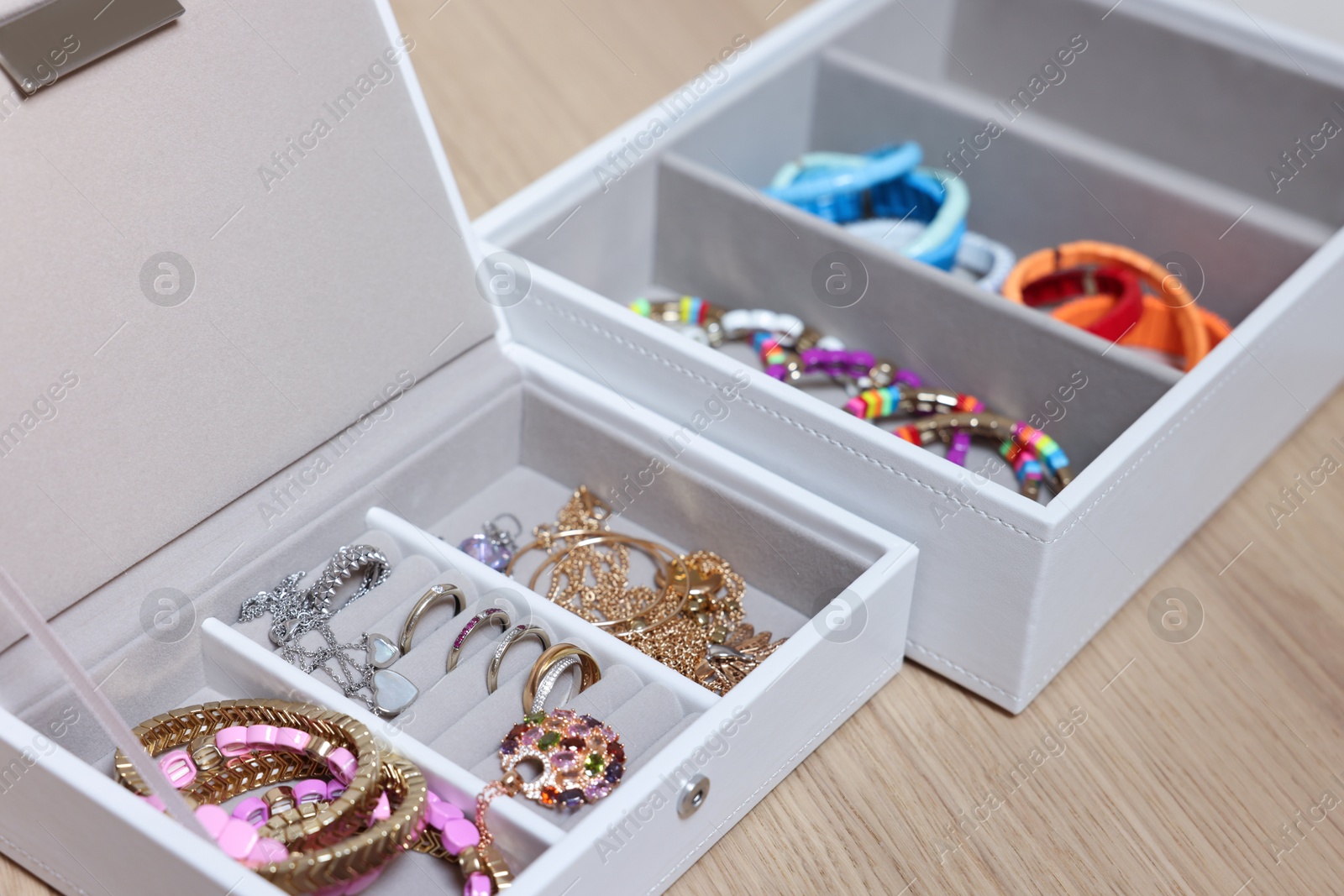 Photo of Jewelry boxes with stylish bracelets and other accessories on wooden table