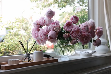 Photo of Beautiful pink peonies in vase on window sill. Interior design