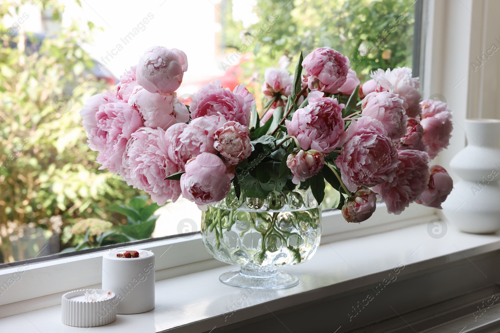 Photo of Beautiful pink peonies in vase on window sill. Interior design