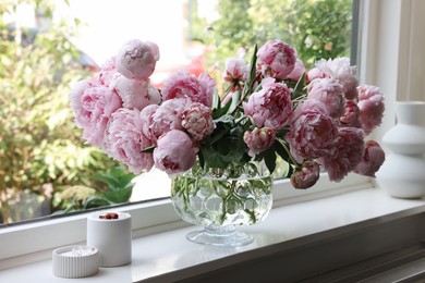 Photo of Beautiful pink peonies in vase on window sill. Interior design