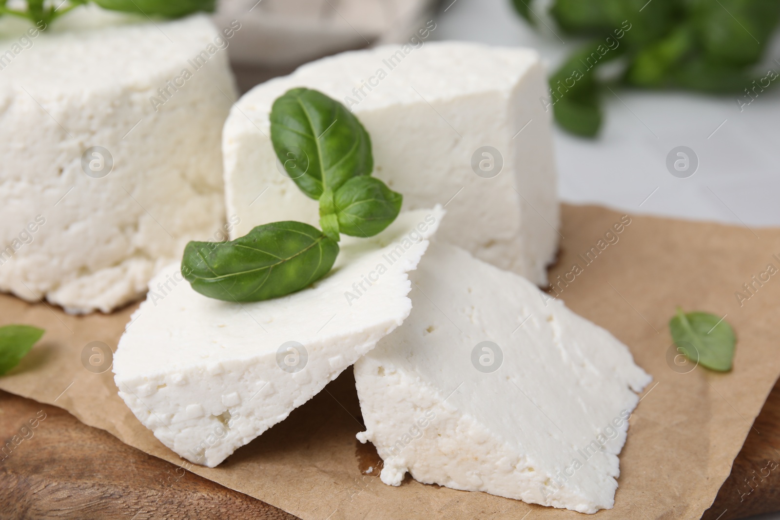 Photo of Fresh ricotta (cream cheese) and basil on table, closeup