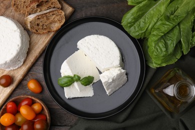 Photo of Fresh ricotta (cream cheese), basil and other products on wooden table, flat lay