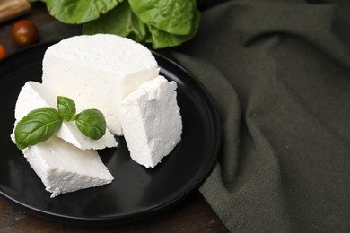 Photo of Fresh ricotta (cream cheese) and basil on table, closeup. Space for text