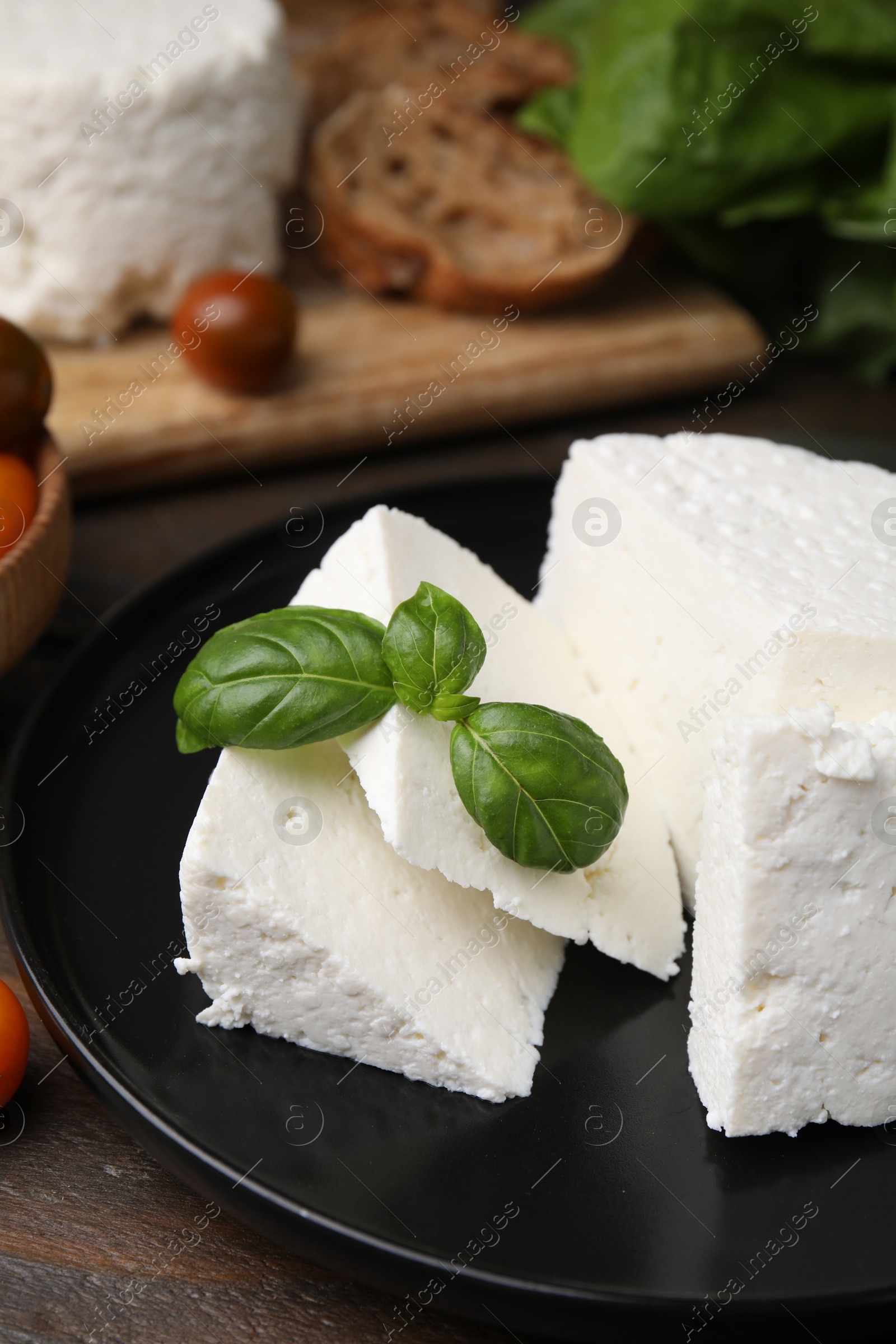 Photo of Fresh ricotta (cream cheese) and basil on table, closeup